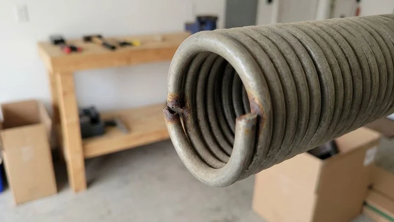Broken garage door torsion spring showing visible gap in the coil